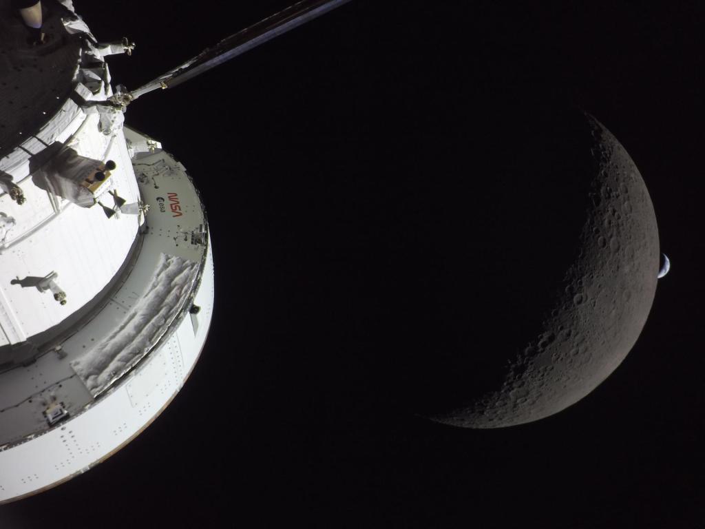 View of the Moon from a spacecraft, showcasing the lunar surface and the spacecraft's exterior with a dark space background.